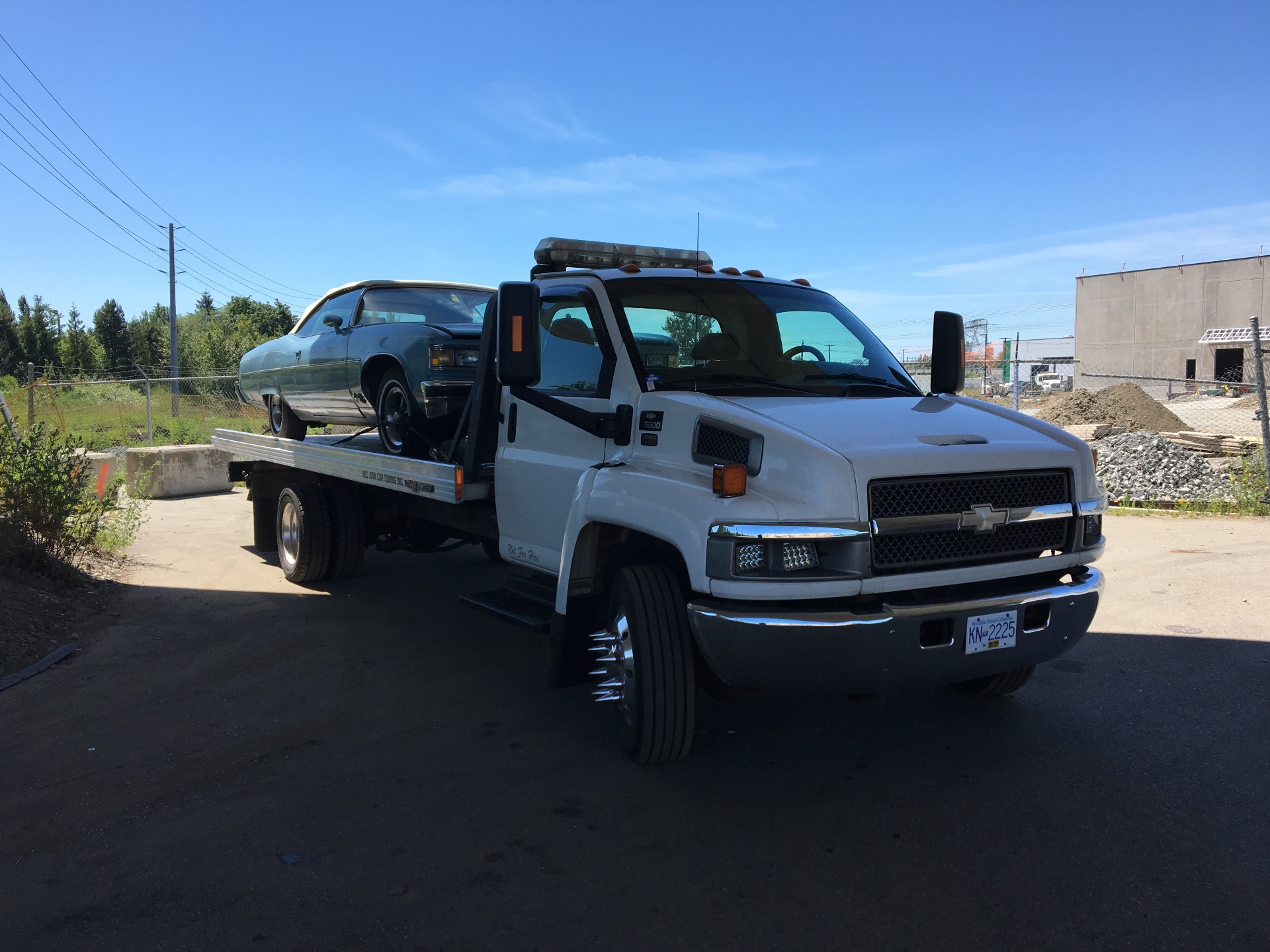 Our flatbed tow truck picking up a classic sedan in the Lower Mainland