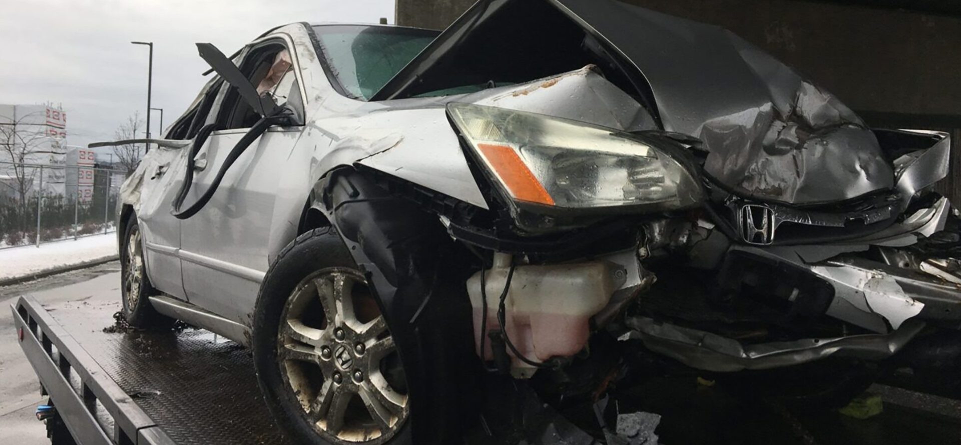 Severely damaged car after an accident, ready for Scrap Car Removal, with a crumpled front end and deployed airbags.