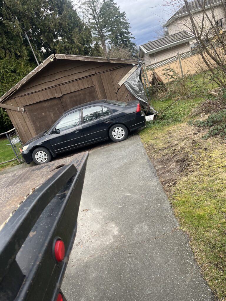Scrap car removal from a damaged garage in the Lower Mainland. Jay from CashForCarsBC safely removed the vehicle using a tow truck winch.
